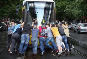 Fahrgäste schieben eine Tram